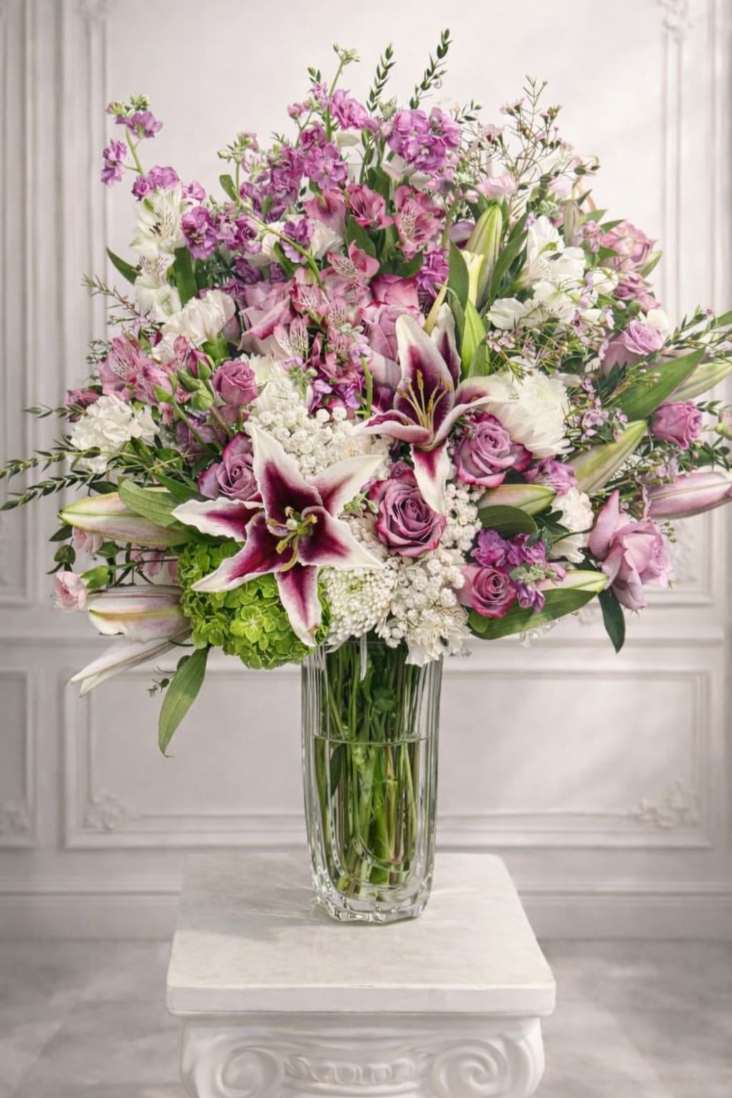 Large bouquet of pink and white flowers in a clear glass vase