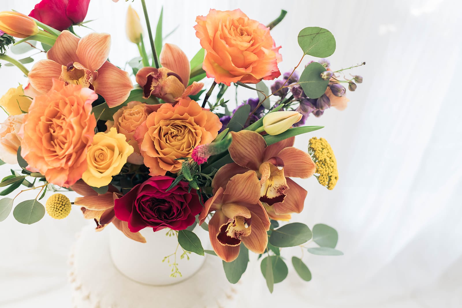 Bouquet of orange and red flowers in a white vase