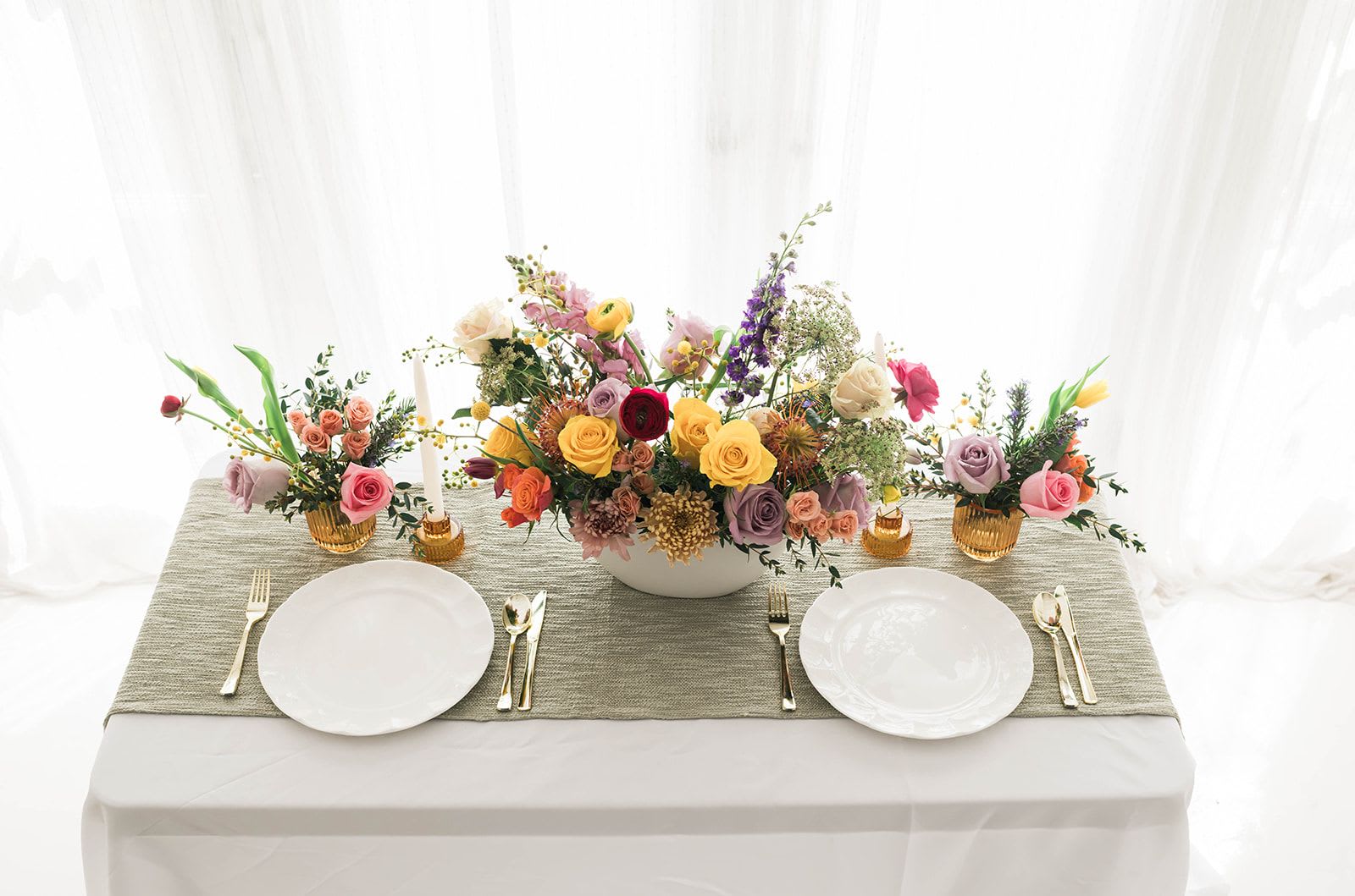 Floral table centerpiece with roses and mixed blooms on a dining table