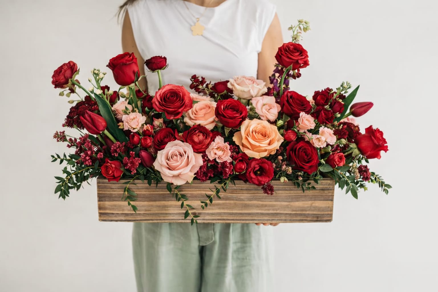 Long wooden box arrangement of red and blush roses