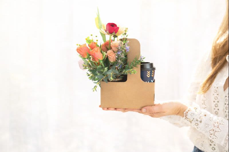 Mixed bouquet in a cardboard gift box with a travel cup