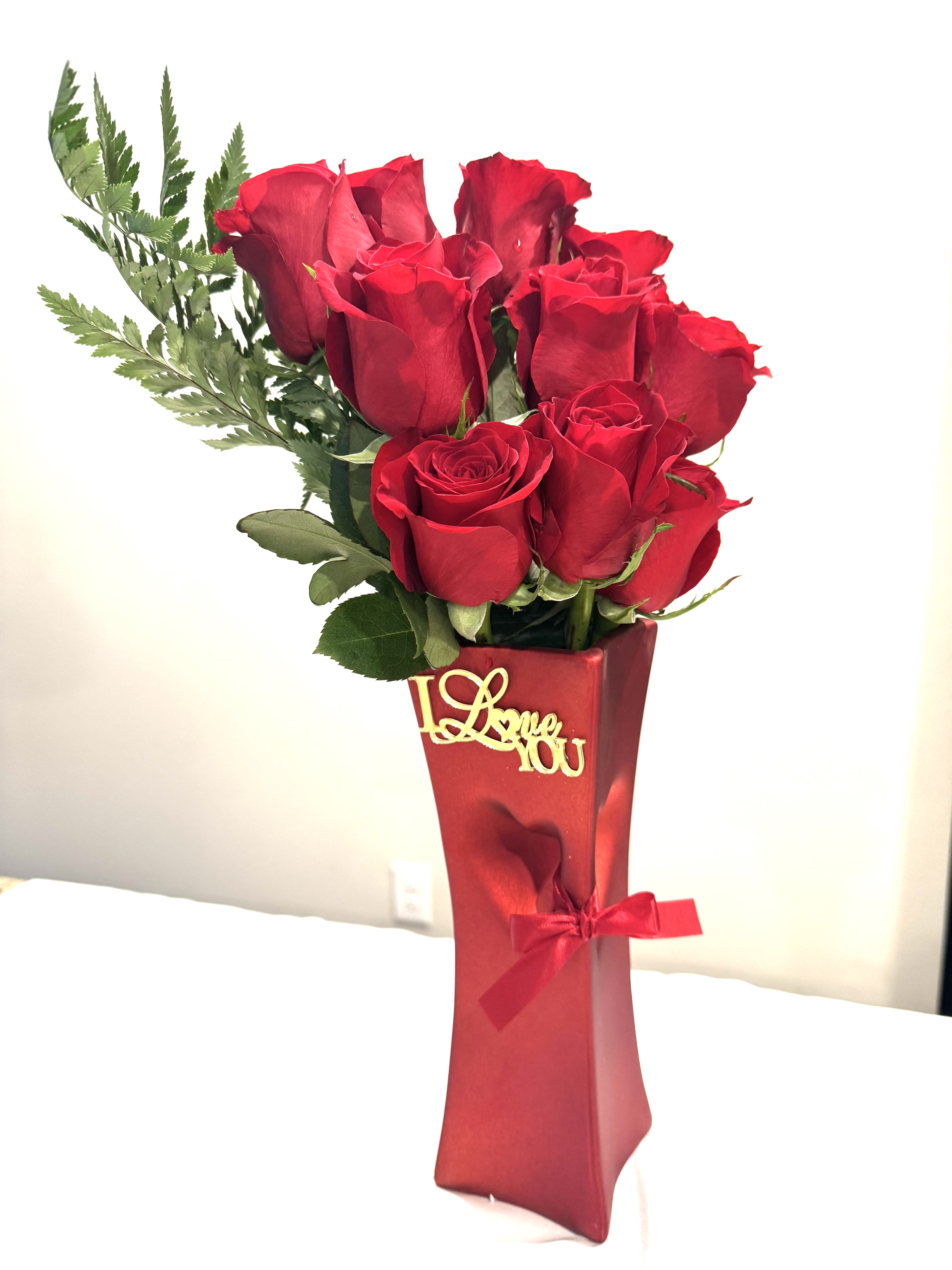 Red roses in a tall red gift box with a ribbon