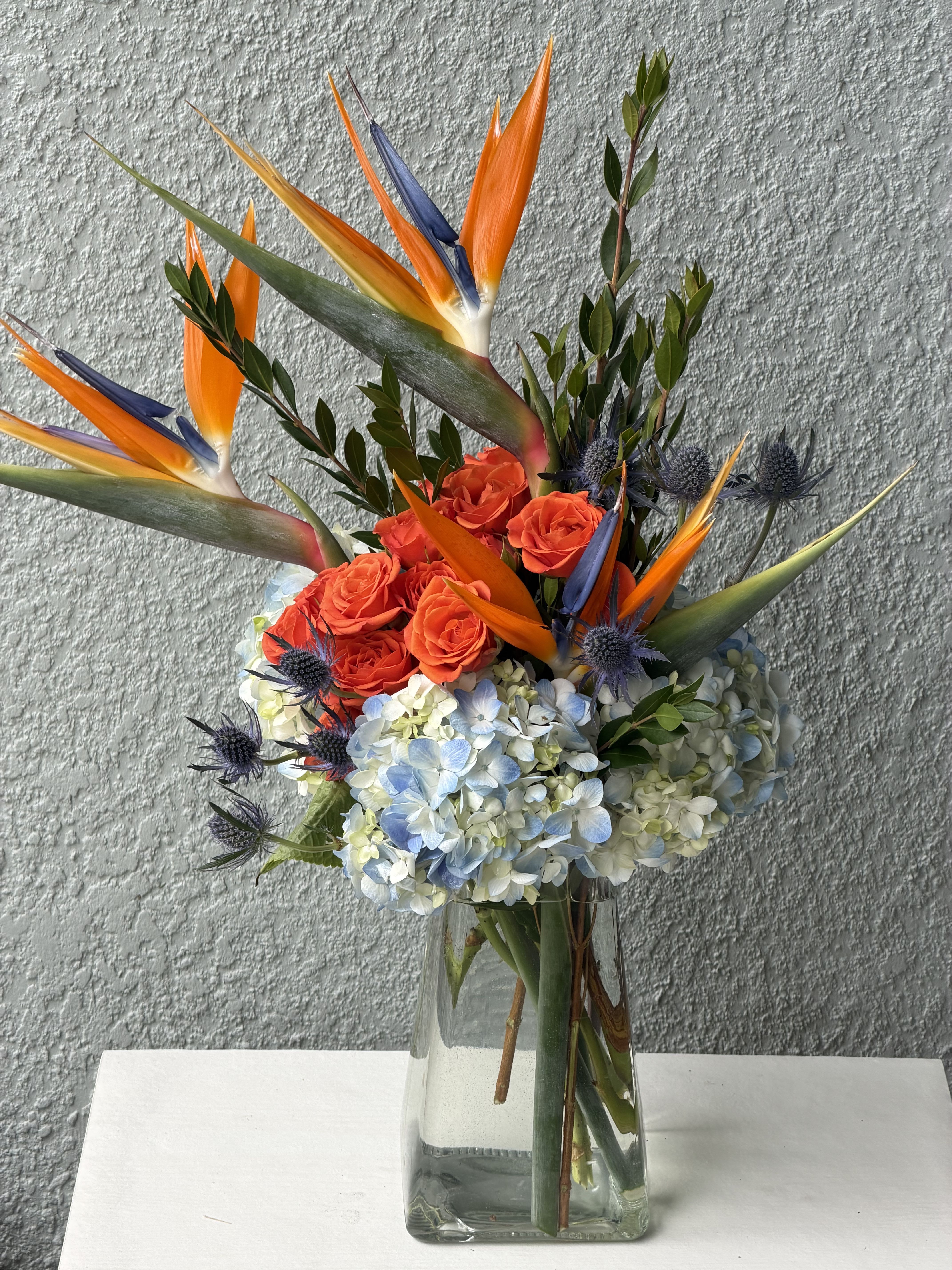 Paradise by bliss  - Perfect for birthdays, celebrations, corporate gifts, housewarmings, or simply brightening someone’s day, this arrangement is thoughtfully designed to leave a lasting impression. Arranged in a sleek glass vase, it offers a contemporary look that complements both homes and offices.
