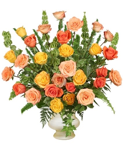 Mixed roses in peach, yellow, and coral in a white vase