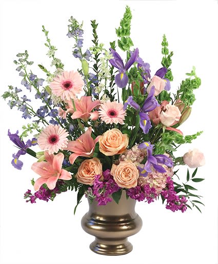 Mixed pink, purple, and peach flowers in a gold vase