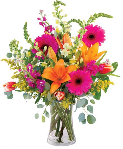 Bright mixed bouquet with orange lilies and pink gerbera daisies in a clear vase
