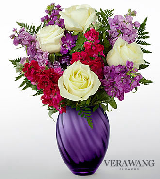 The FTD® Spirited™ Bouquet by Vera Wang - V21S  FTD® proudly presents the Vera Wang Spirited™ . Boasting a bold sophistication and runway ready styling that is synonymous with the name Vera Wang, this gorgeous bouquet is one your special recipient will always remember. Featuring elegant white roses surrounded by an assortment of fragrant purple gilly flower stems, perfectly accented with lush greens, this flower arrangement is spirited indeed. Presented in an attractive deep purple glass vase, this Vera Wang flower bouquet is set to impress when sent in honor of a birthday, anniversary, or as a way to express your thanks and gratitude.