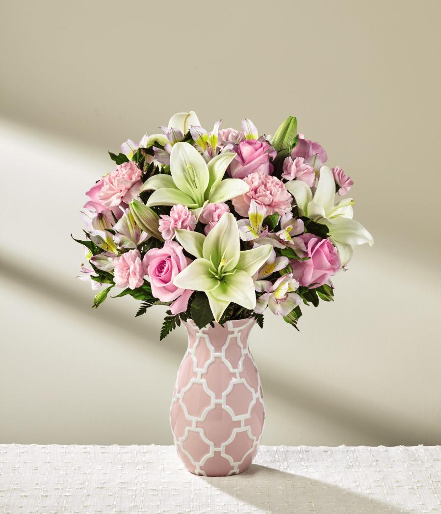 The FTD Perfect Day Bouquet - Deluxe - Sweet, stylish and ready to make your recipient's day, this blushing bouquet is a gift of love and appreciation they will never forget! Pink roses, carnations, and mini carnations delight the senses, offset by white Asiatic Lilies and Peruvian lilies to create an alluring arrangement. Presented in a keepsake pink ceramic vase embossed with an attractive white modern trellis pattern to add even further interest to this already stunning design, this gorgeous flower arrangement is ready to express your warmest wishes in honor of Mother's Day, a birthday, or as a way to simply say thank you. GOOD bouquet includes 11 stems. Approx. 15"H x 12"W. BETTER bouquet includes 15 stems. Approx. 16"H x 13"W. BEST bouquet includes 19 stems. Approx. 17"H x 14"W. EXQUISITE bouquet includes 23 stems. Approx. 18"H x 14"W.