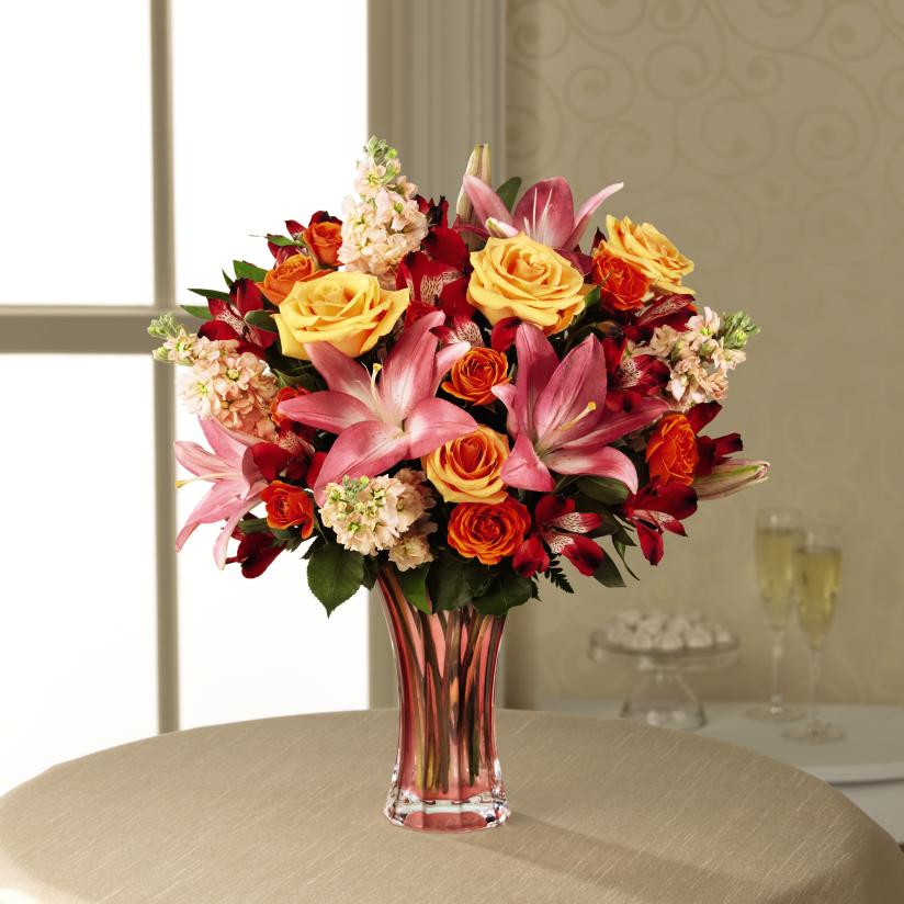 The FTD Touch of Spring Bouquet - Deluxe - The arrival of spring brings a new bounce to our steps and a light in our eye that makes life a bit sweeter than it was during the cold and sometimes dreary days of winter. Celebrate spring's arrival with a bold mix of glorious flowers, offering warmth and beauty to any space with it's combination of peach roses, peach gilly flower, orange spray roses, red Peruvian Lilies and Pink Asiatic Lilies. Arranged perfectly within a keepsake blushing glass vase, this gorgeous flower bouquet is a wonderful way to convey your sweetest wishes in honor of a birthday, anniversary, Easter, or Mother's Day. GOOD bouquet includes 11 stems. Approx. 18"H x 16"W. BETTER bouquet includes 16 stems. Approx. 18"H x 19"W. BEST bouquet includes 18 stems. Approx. 19"H x 20"W. EXQUISITE bouquet includes 22 stems. Approx. 20"H x 20"W.