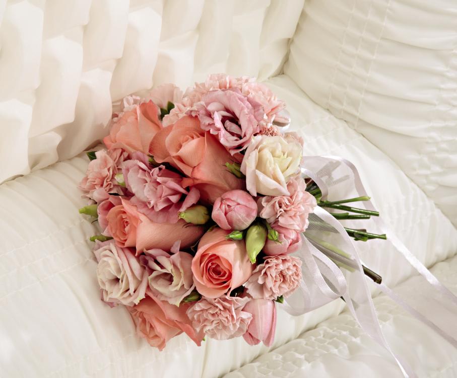 FTD Heartfelt Condolences Casket Adornment - "  The FTD Heartfelt Condolences Casket Adornment is a sweet accent   piece to honor the life of the deceased at their memorial service.   Blushing pink roses, tulips, double lisianthus and mini carnations are   brought together to create a delicately beautiful bouquet, accented with   a light sheer pink ribbon, that perfectly expresses your love and   affection for the departed.      9""h x 8""w  "