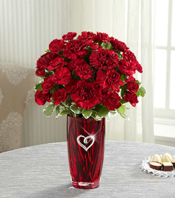 The FTD® Sweethearts®Bouquet - When you're "red-dy" for romance, this rich, lush bouquet of vibrant red makes a sure-fire way to let that special someone know. This brilliant burst of red and burgundy carnations and red roses (in Deluxe, Premium, and Exquisite versions) are individually hand-selected and hand-arranged by an FTD artisan florist in a heavy, red glass vase embellished with a modern, silvery metal heart clip that can be removed and cherished as a loving keepsake of this magnificent bouquet. Your purchase includes a complimentary personalized gift message.