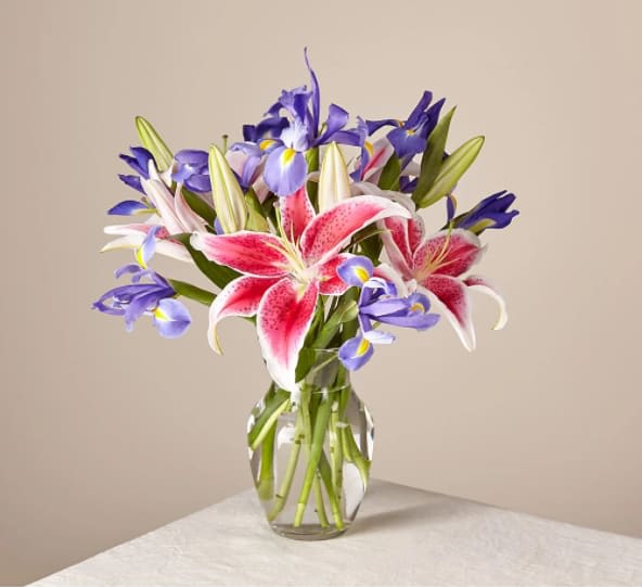 Belle of the Ball Bouquet - Arranged with elegant florals and fragrance, this show-stopping collection of lilies and irises shares the perfect expression for any reason or occasion. Please note, the flowers in this farm-fresh bouquet arrive in bud form only to bloom beautifully shortly after it arrives.  The Original Bouquet is about 18"H by 20"W.
