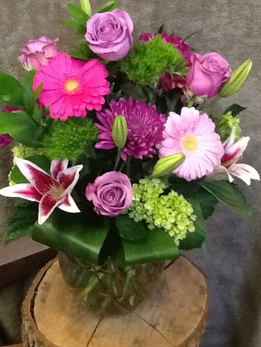 Mixed bouquet of pink and purple flowers in a glass vase