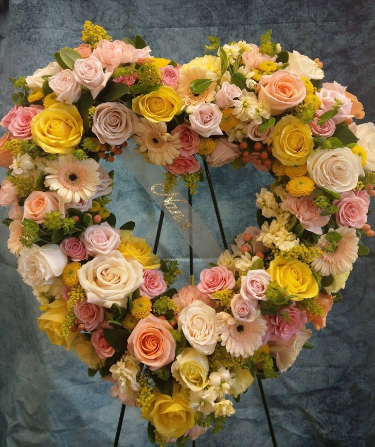 Heart-shaped floral wreath with roses, gerbera daisies, and yellow blooms