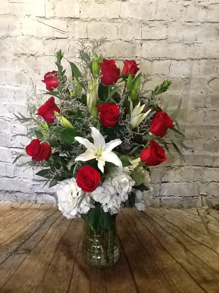 Red roses and white lilies in a clear glass vase