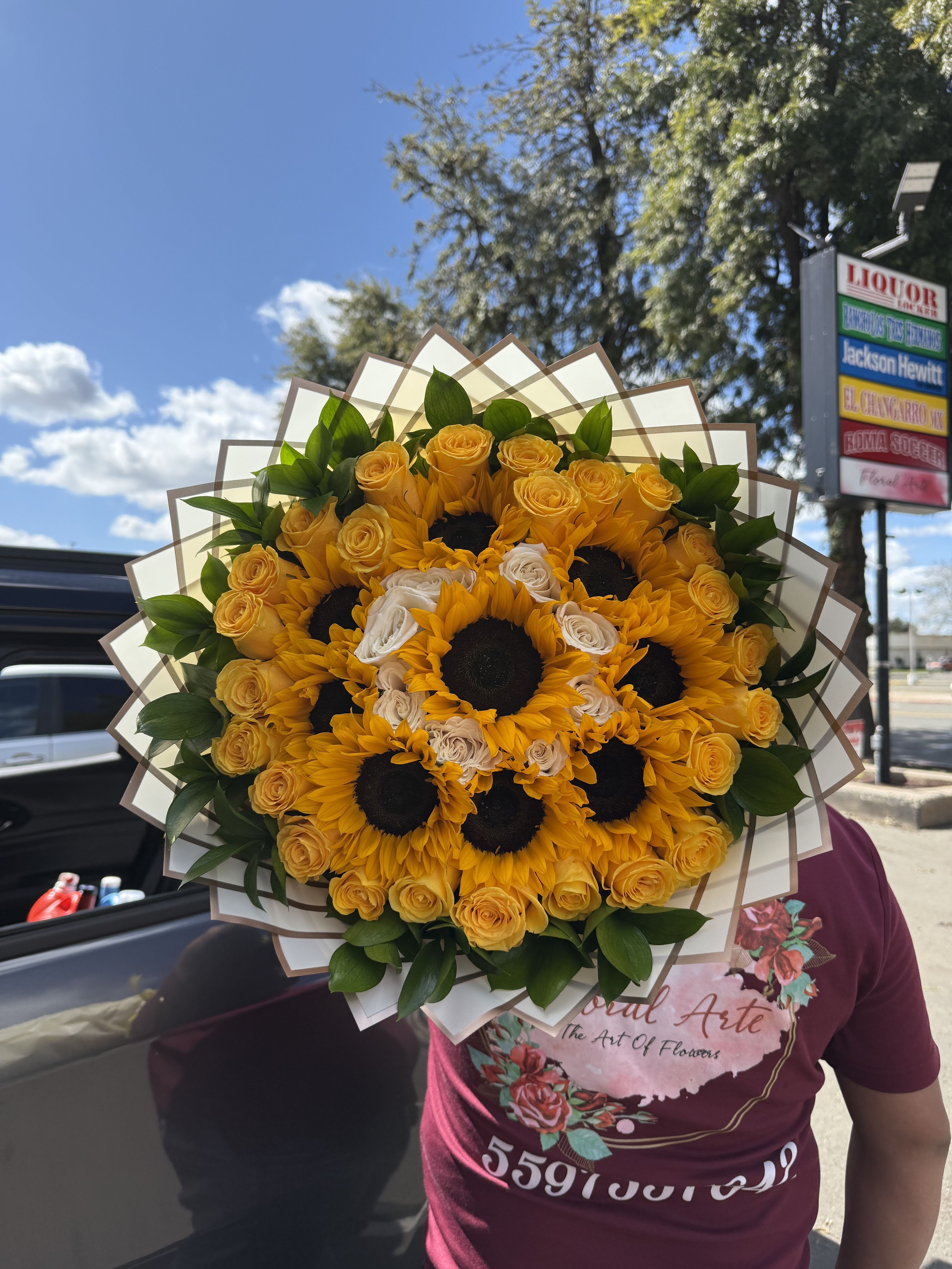 Bouquet of yellow sunflowers and roses wrapped in paper