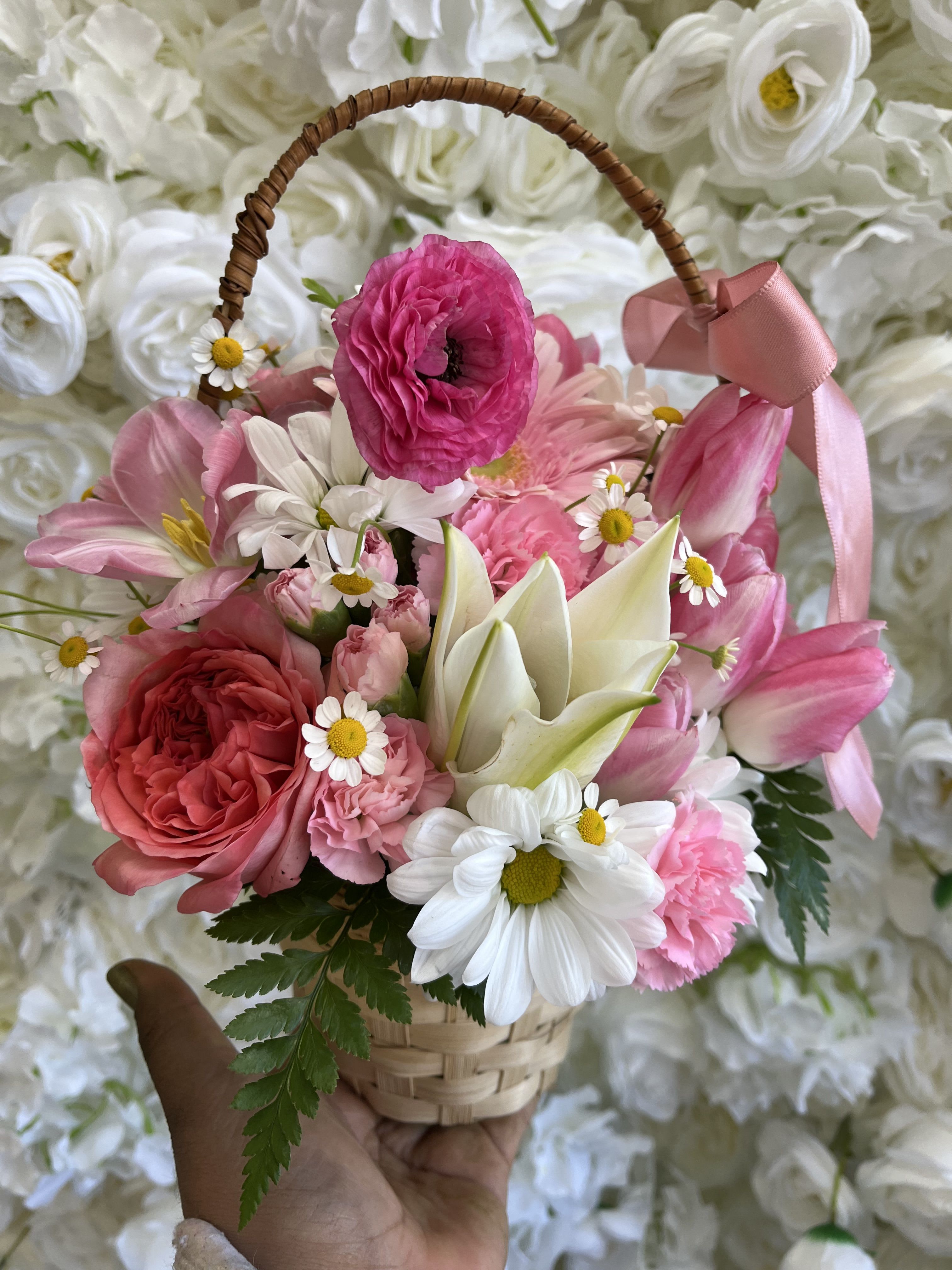 Pink and white flower basket with a ribbon handle