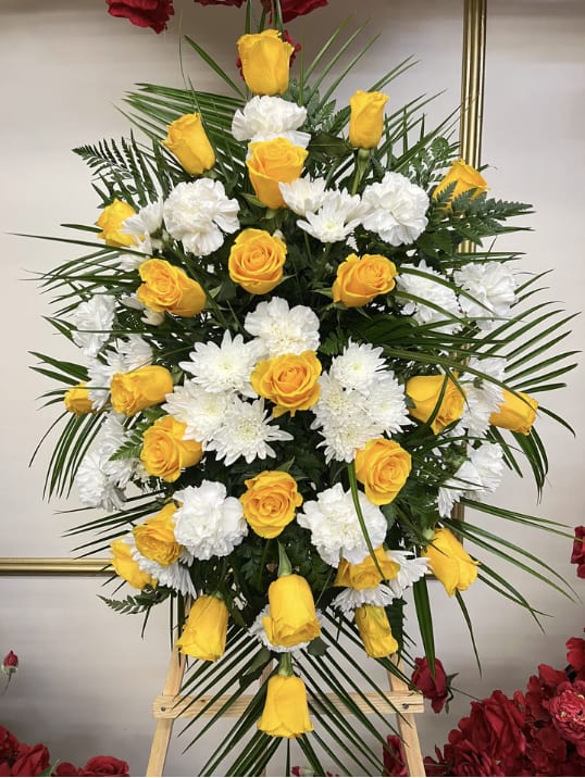 Yellow roses and white chrysanthemums in a tall standing arrangement
