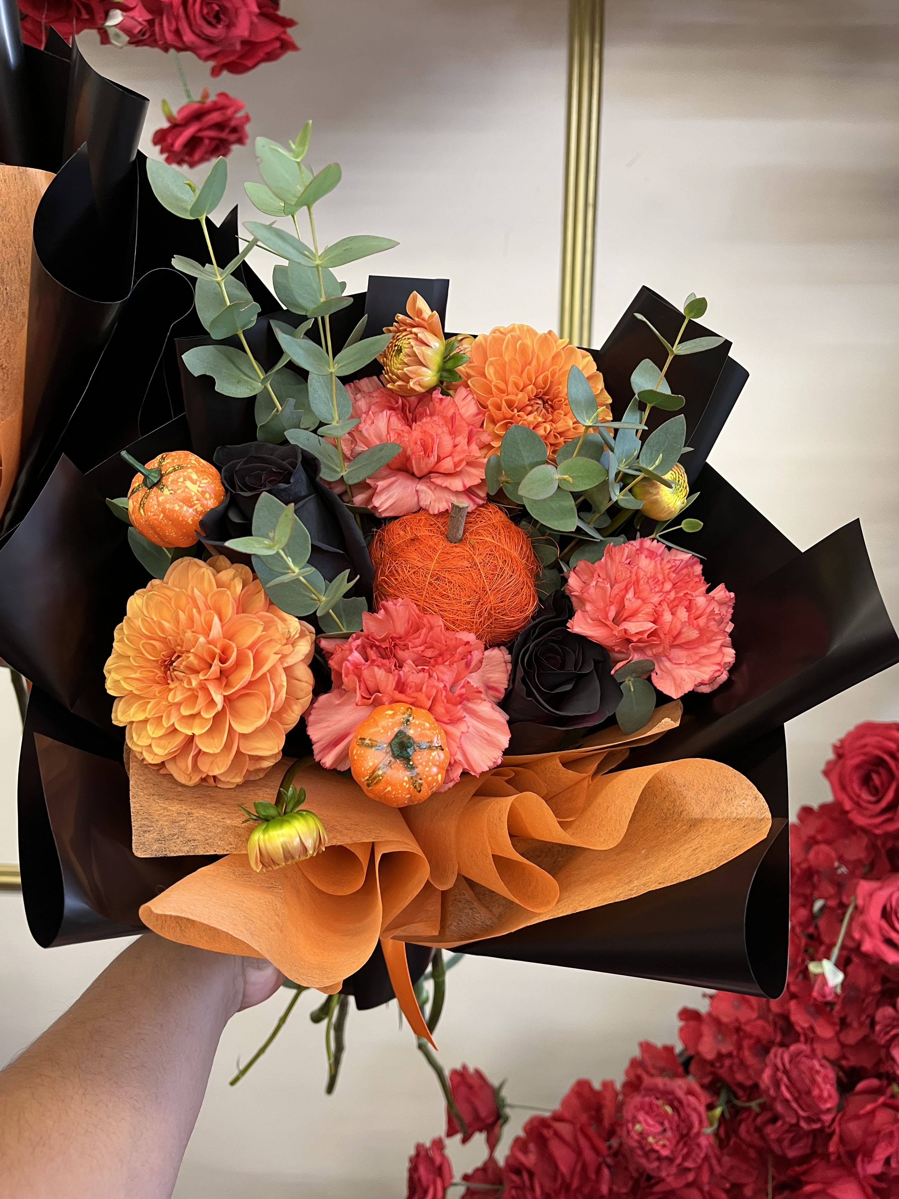 Bouquet of orange and pink flowers with black and orange wrapping