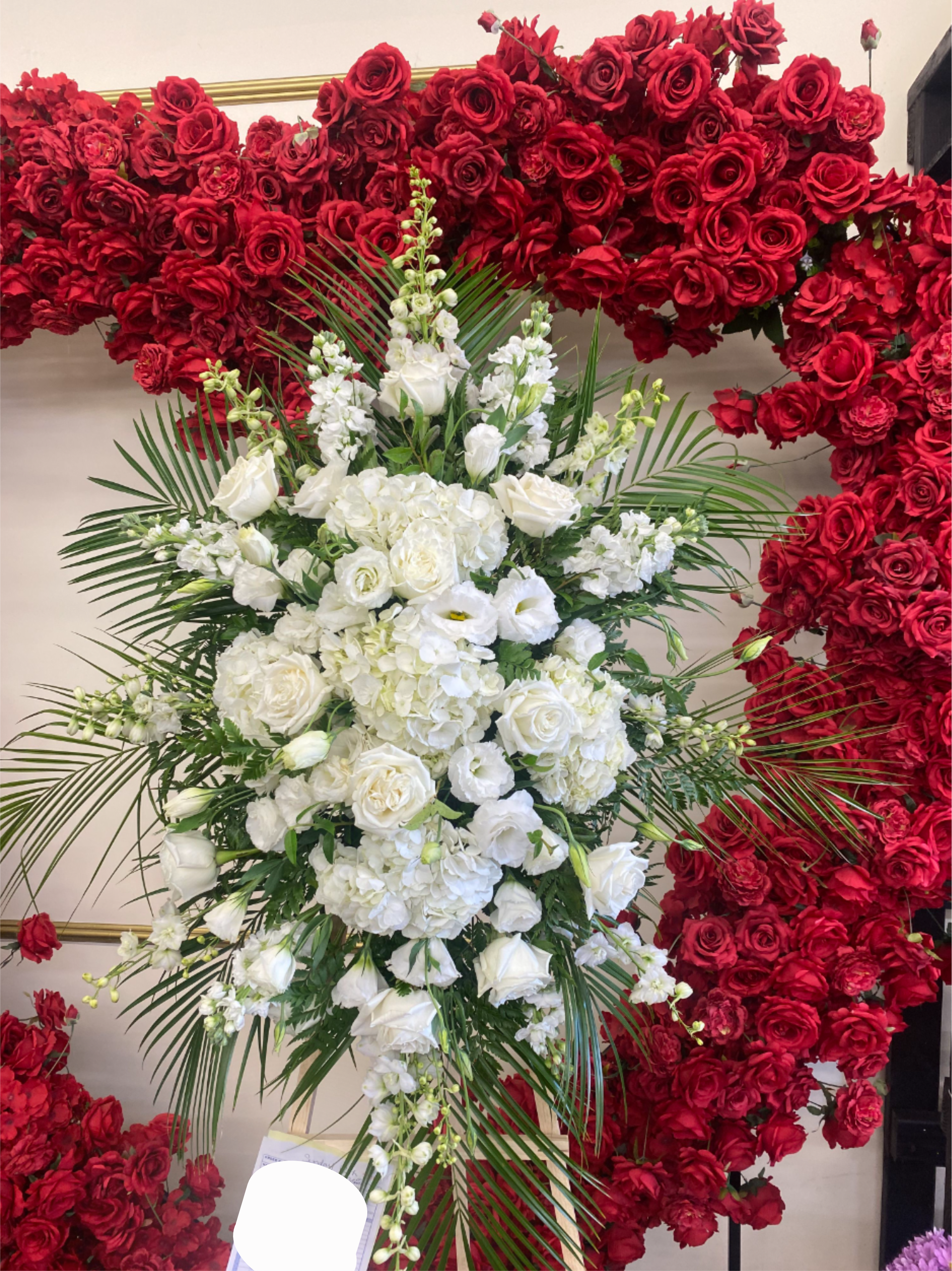 Classic Standing Spray- White  - Our Standing Sympathy Spray is a beautiful expression of comfort and support, thoughtfully designed to honor a loved one’s memory. Featuring a graceful combination of roses, hydrangeas, and complementary blooms, this arrangement is crafted with care to provide a timeless tribute.  Note: PICTURED IS THE PREMIUM SIZE. Easel is INCLUDED