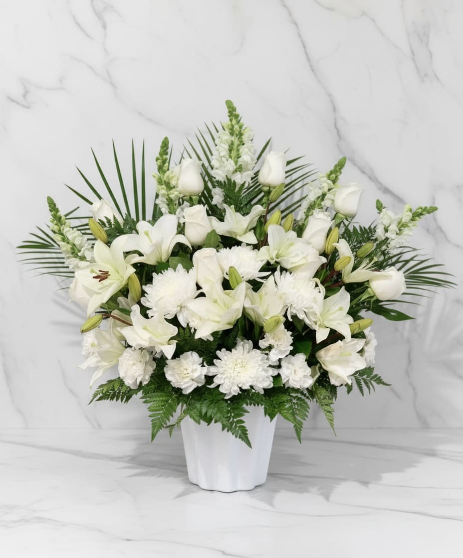 White lilies and chrysanthemums arranged in a white vase