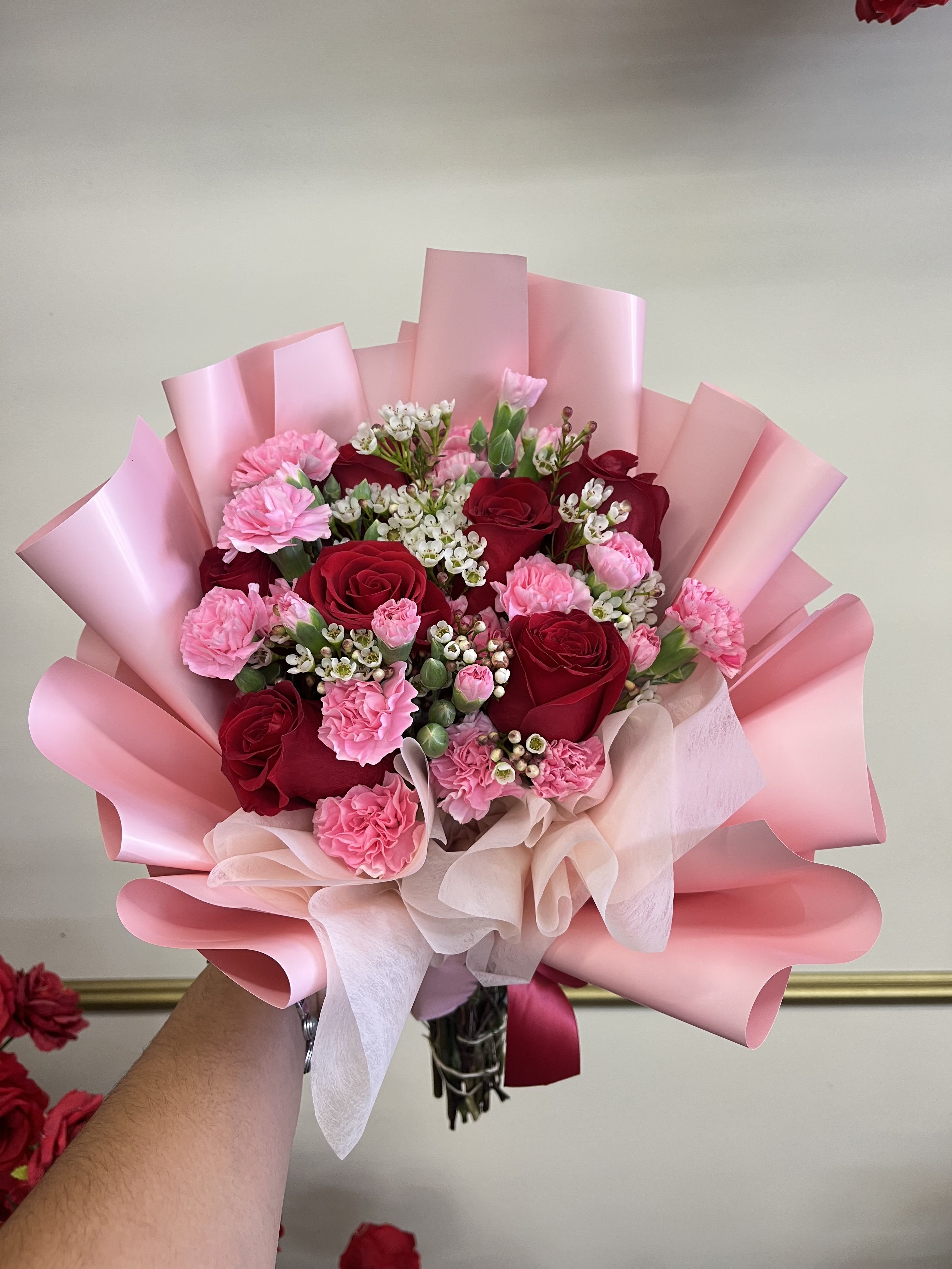 Pink and red rose bouquet with carnations wrapped in pink paper