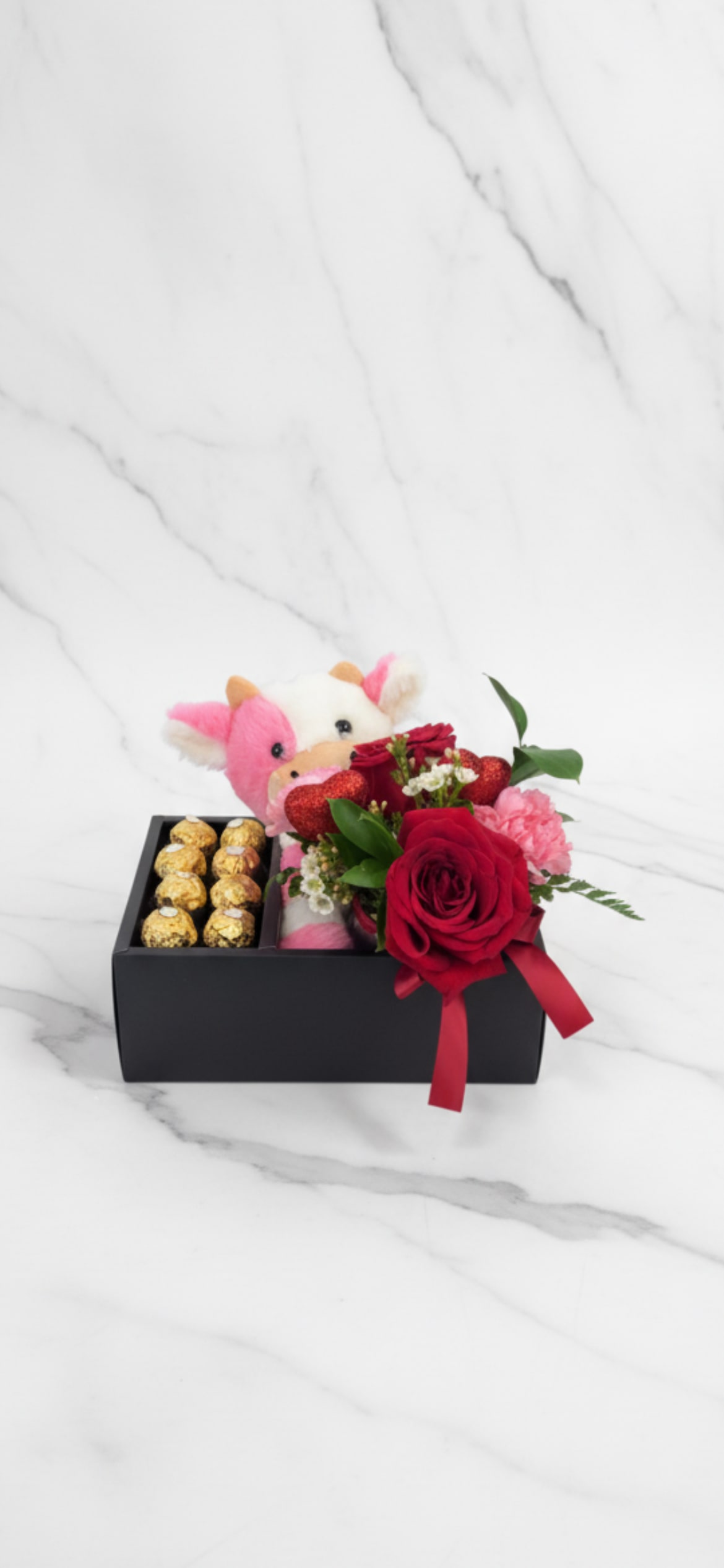 Gift box with a plush cow, red roses, and chocolates