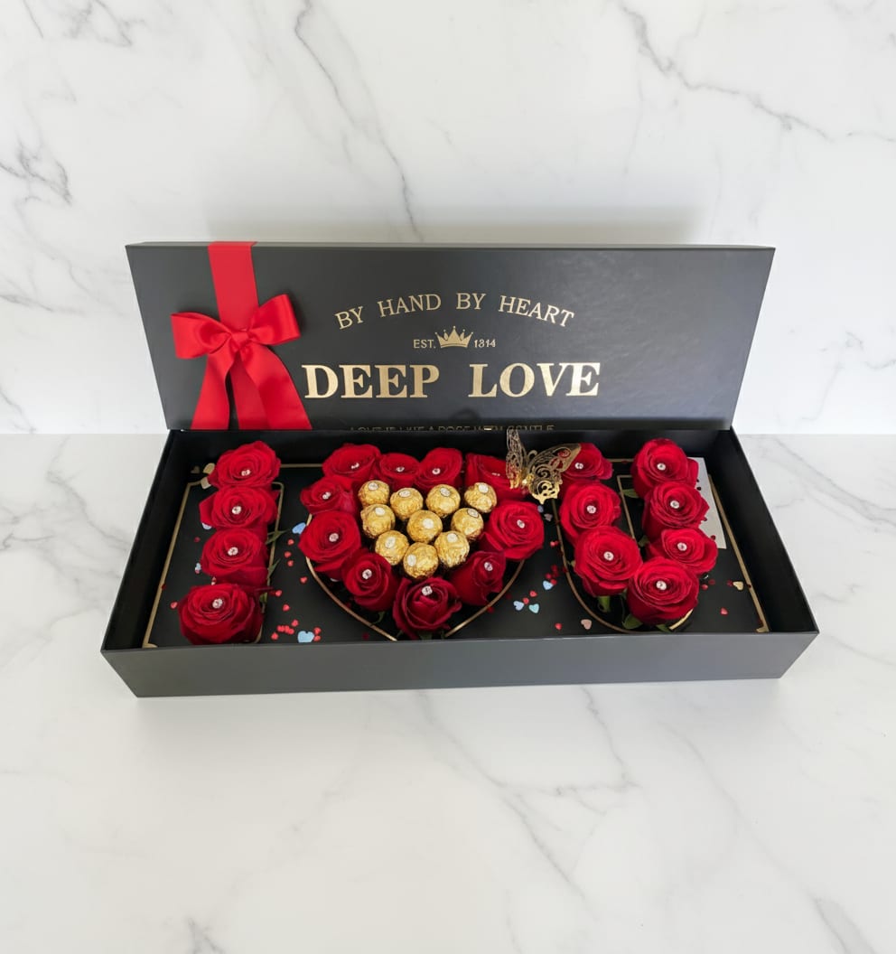 Red roses and chocolates arranged in a black gift box