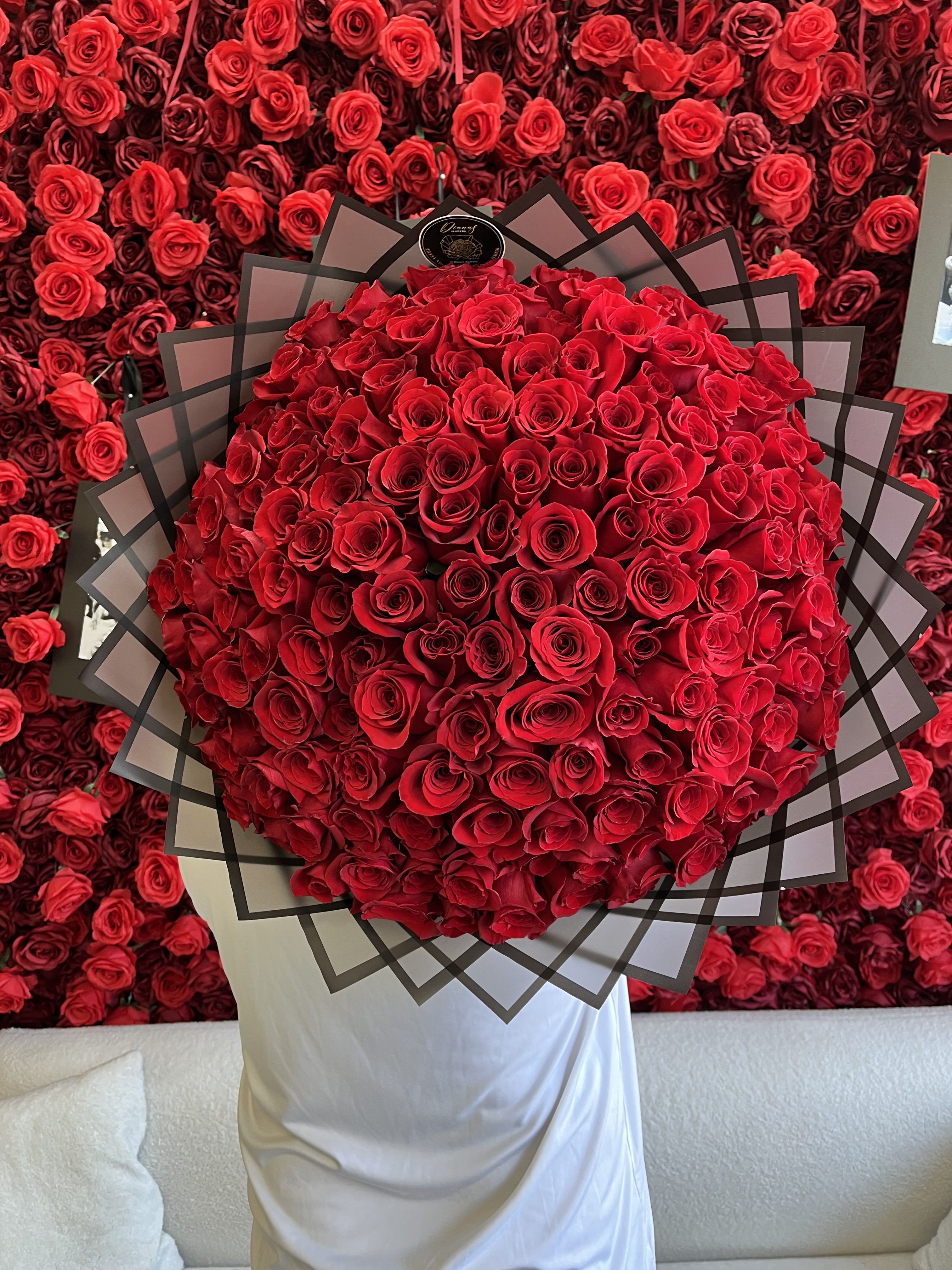 Large bouquet of red roses wrapped in black-edged paper