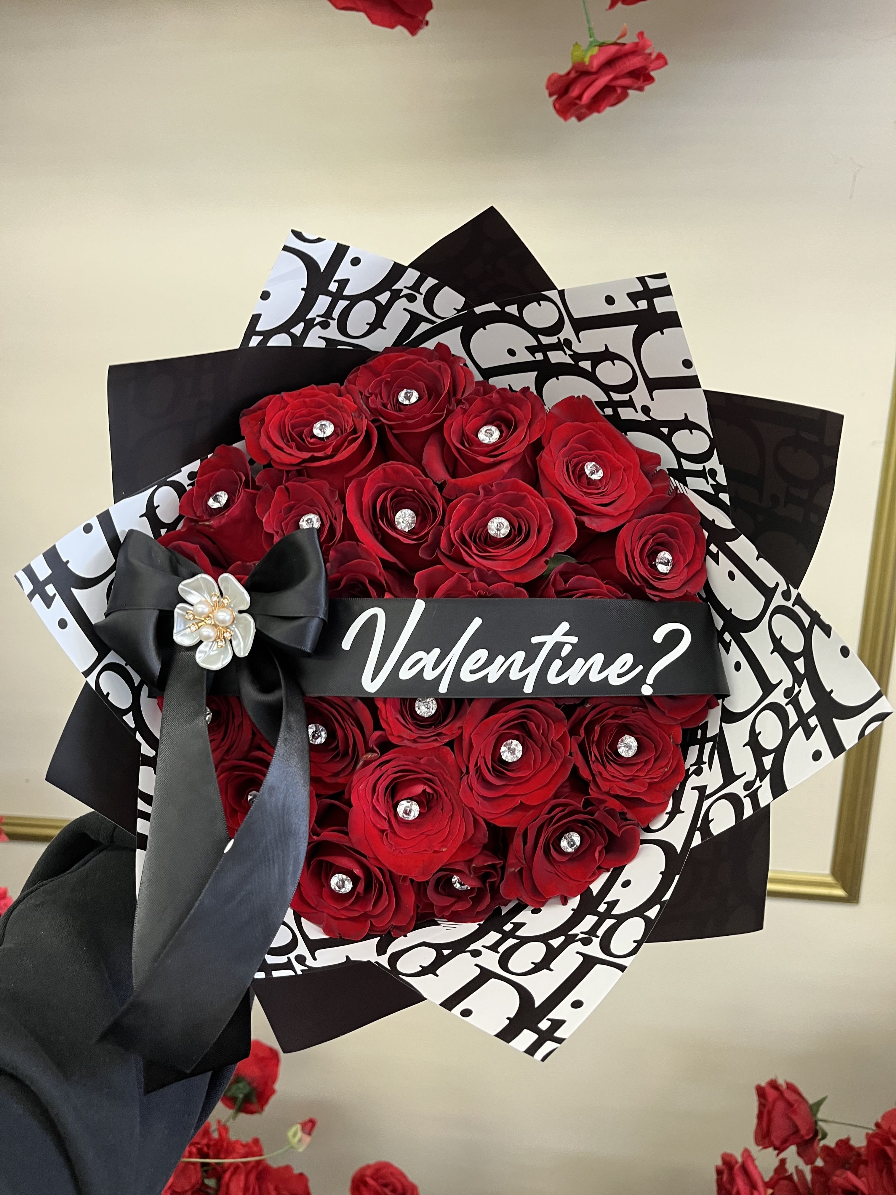 Bouquet of red roses wrapped in black and white paper with a black bow