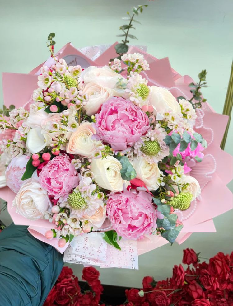 Pink and white bouquet with peonies and roses wrapped in pink paper