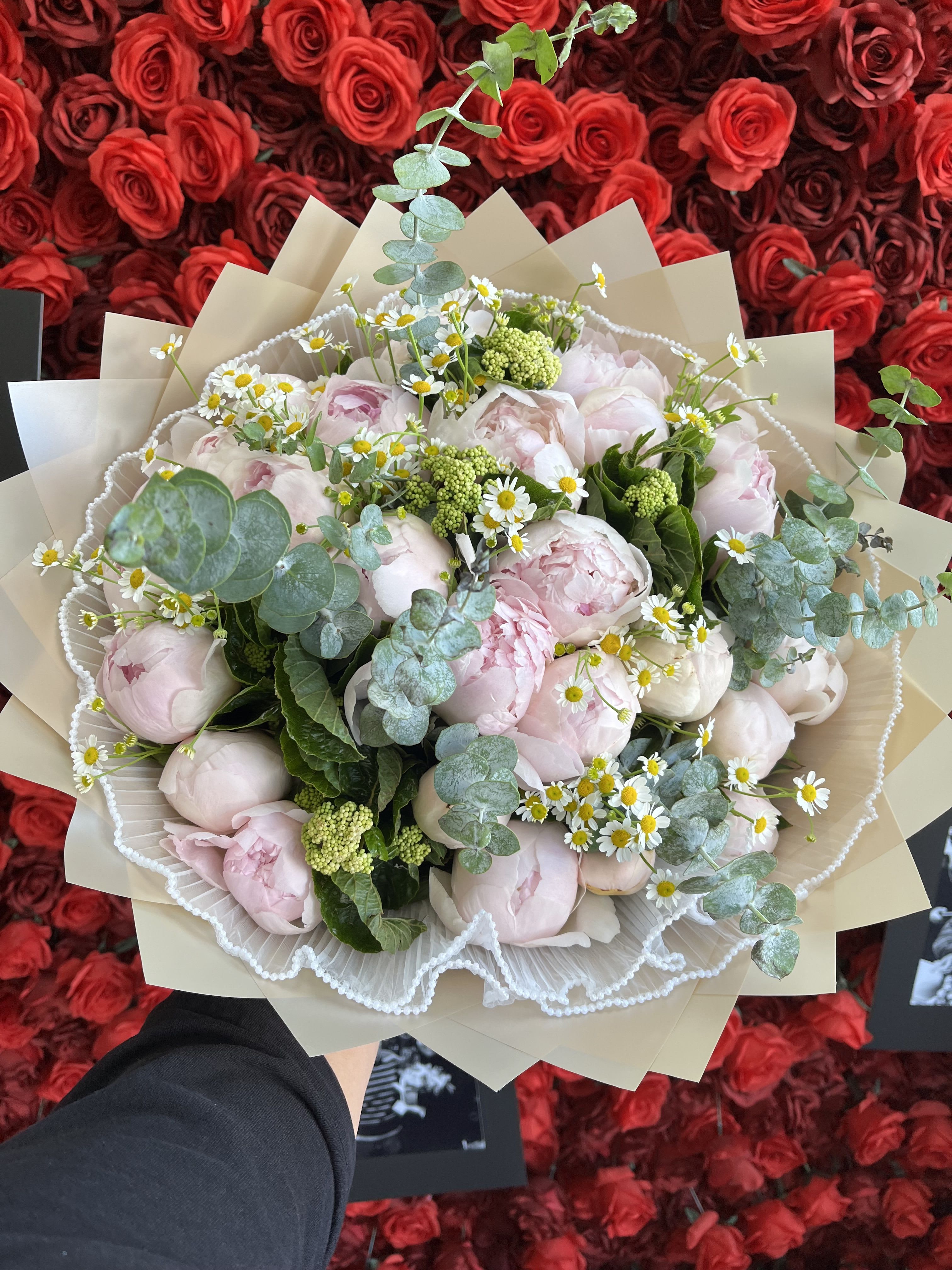 Bouquet of pale pink peonies with small white daisies and eucalyptus
