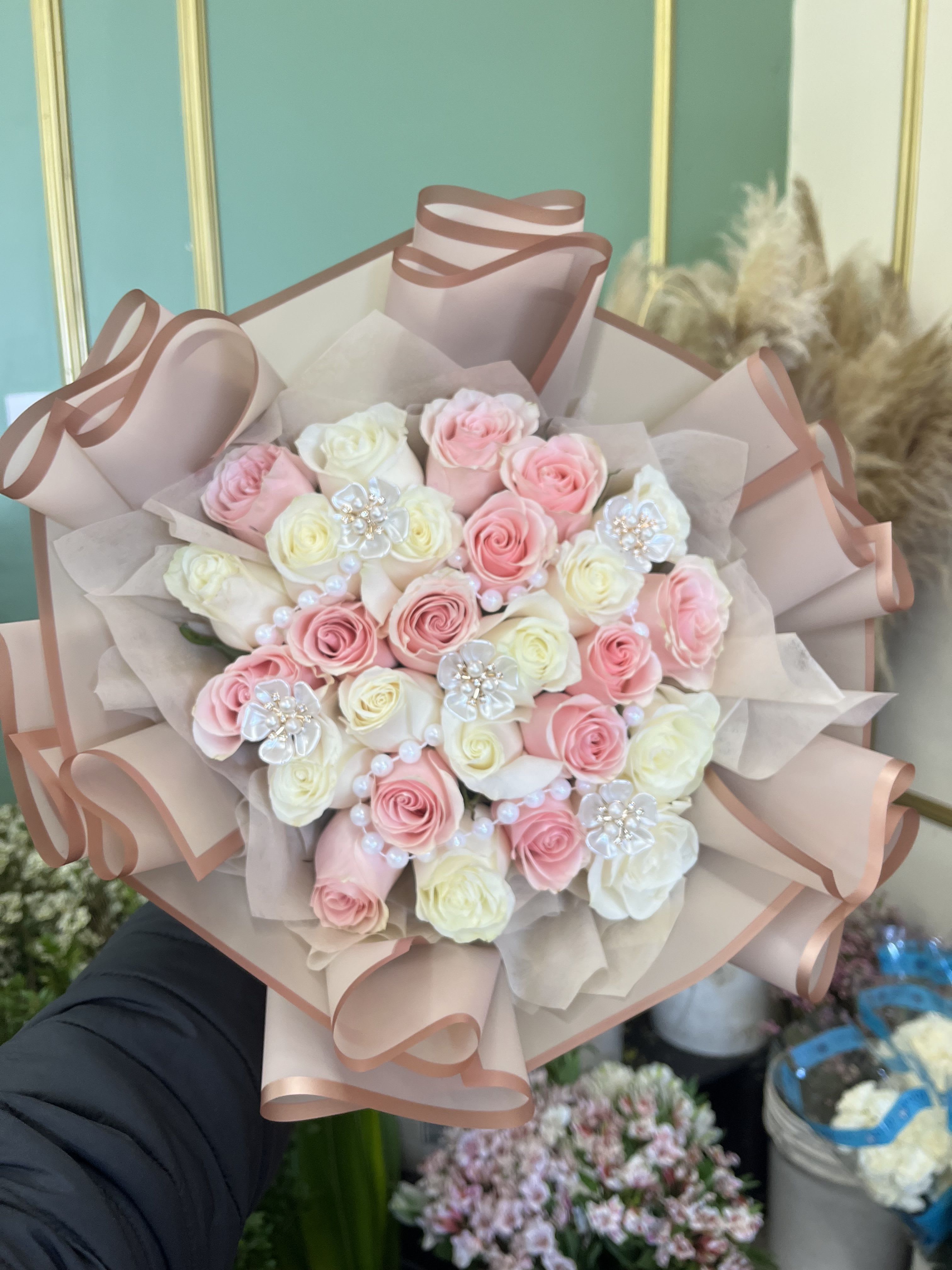 Bouquet of pink and white roses wrapped in blush paper