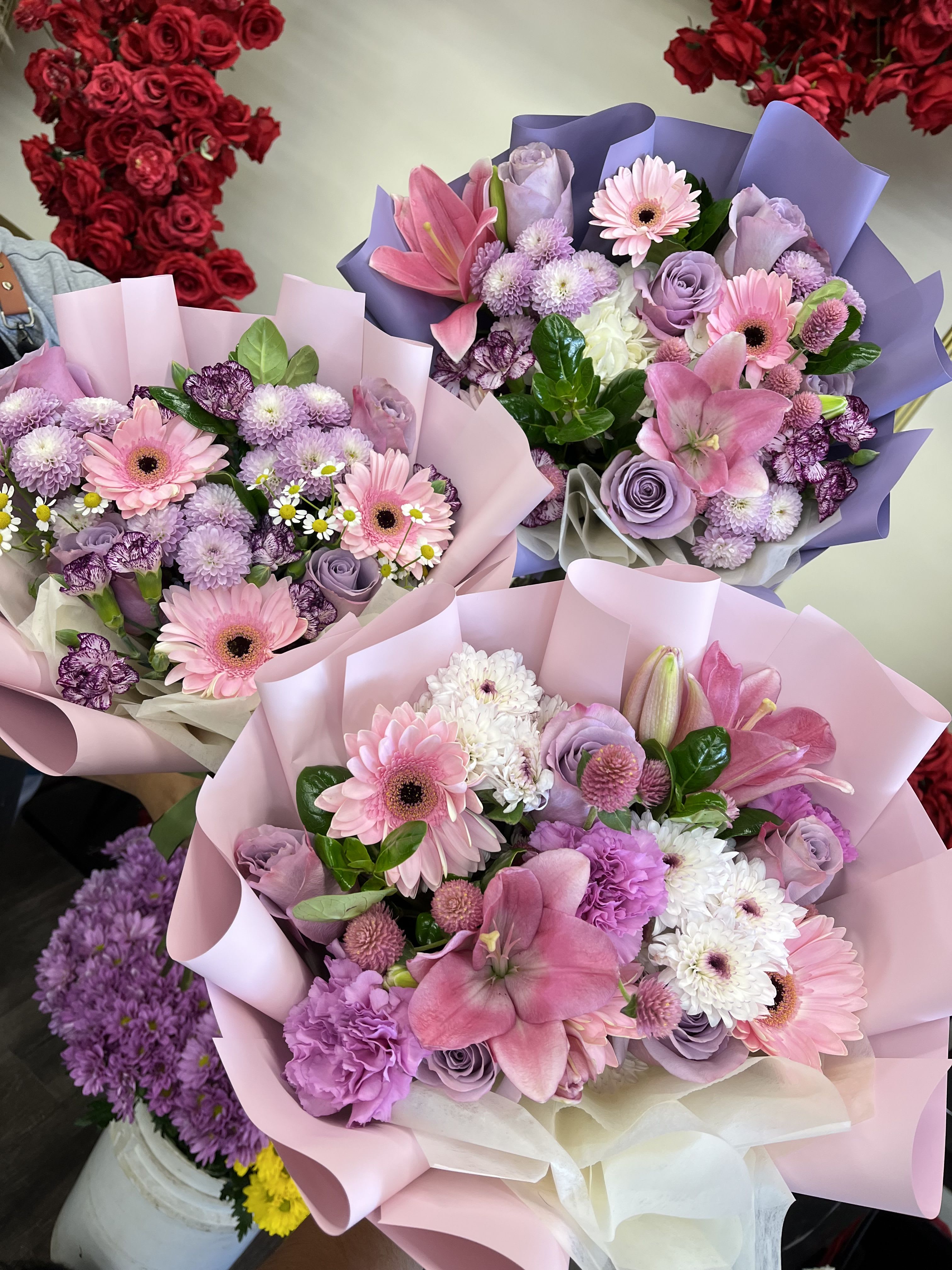 Florist choice- Lavender Dreams - Florist, choice Pink and lavender bouquet mix of gerbera, roses, lilies and carnations with white accents-soft, romantic hand-tied blooms wrapped in pastel paper, perfect for joyful celebrations.
