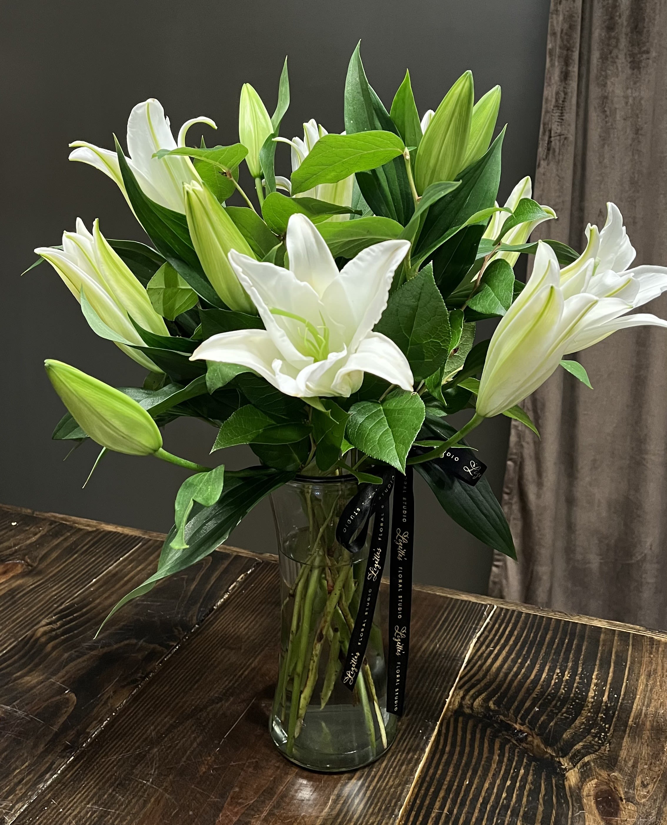 Lily Élan - Lily Élan is a graceful all-lily arrangement that celebrates timeless elegance with the beauty of fresh, premium lilies. Designed with clean lines and soft movement, this sophisticated floral arrangement brings effortless luxury to any home, celebration, or heartfelt occasion. With their captivating fragrance and refined blooms, Lily Élan makes a striking statement while embodying poise, beauty, and enduring charm.