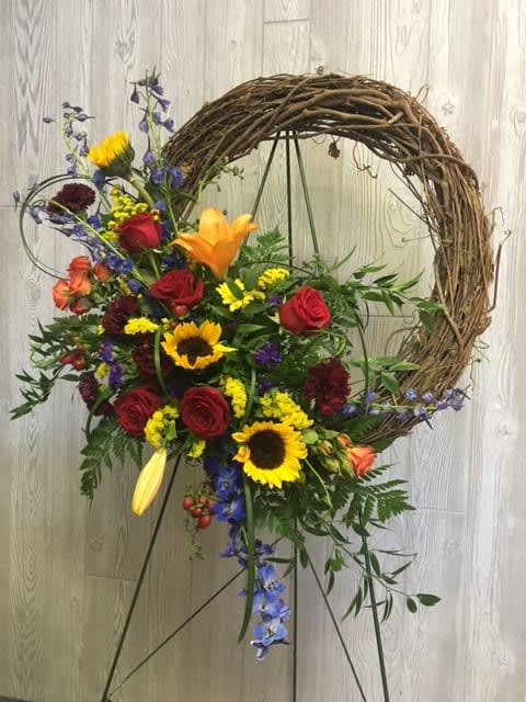 Colorful floral wreath on a stand with roses and sunflowers