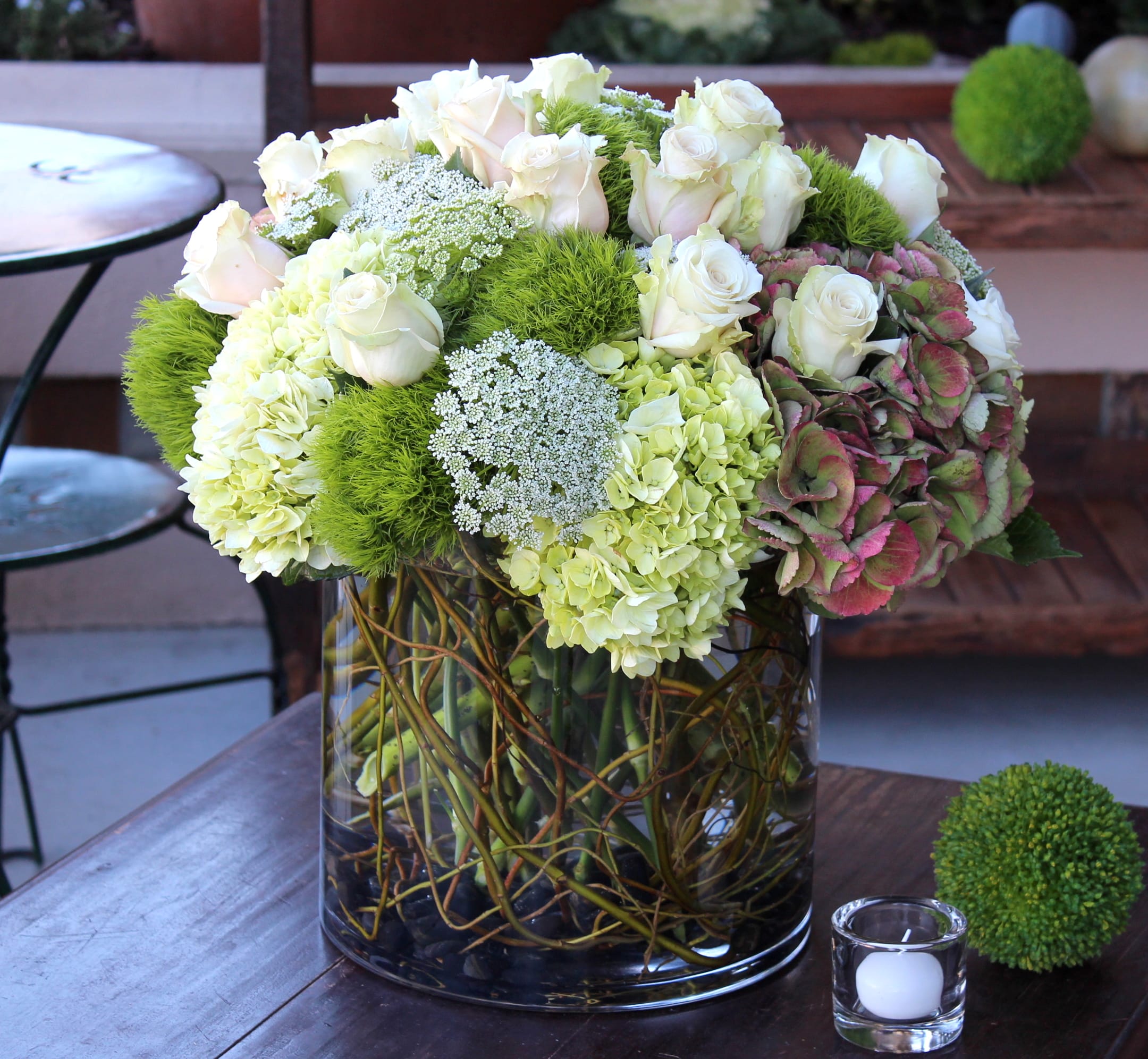 White roses and green hydrangeas in a glass vase