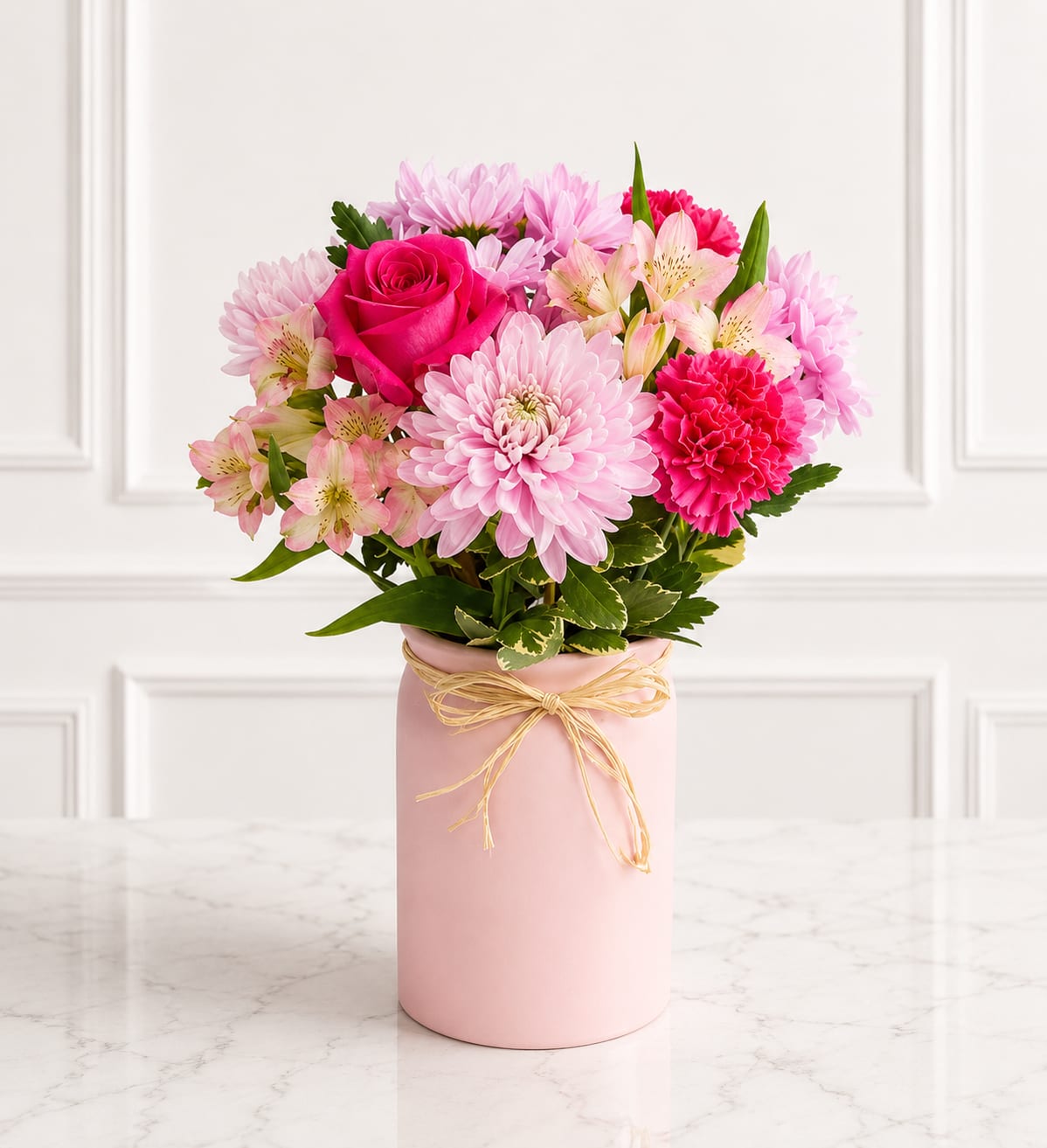 Blush &amp; Bloom Vase™ - Delicate, elegant, and full of charm, Blush &amp; Bloom Vase™ features beautiful pink lilies, vibrant hot pink roses, soft lavender cushion mums, pink stock, snapdragons, and fresh seasonal greenery, all artfully arranged in a stylish blush pink keepsake vase with a rustic raffia bow. This graceful arrangement is perfect for birthdays, anniversaries, Mother's Day, thank-you gifts, get well wishes, or simply brightening someone's day with timeless beauty.