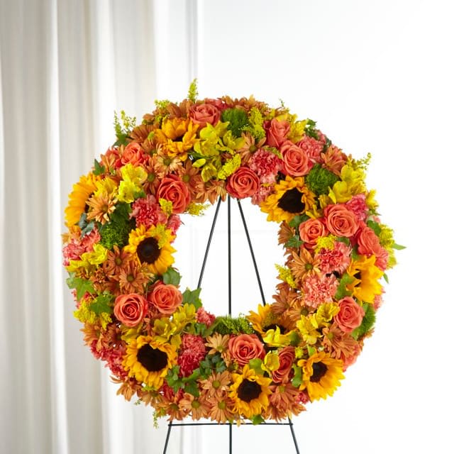 Memories Wreath - Share your sympathies with a stunning harvest wreath that both celebrates the season and their beautiful life. The vibrant shades of fall are curated with a collection of sunflowers, dianthus and roses in our Autumnal Memories™ Wreath. Each stunning bloom delivers your love and reverence with this timeless sympathy tribute. Wreath 