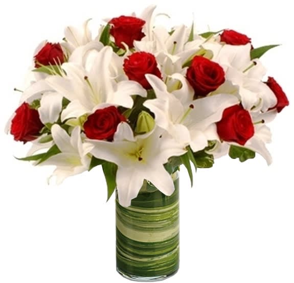 Red roses and white lilies arranged in a green glass vase