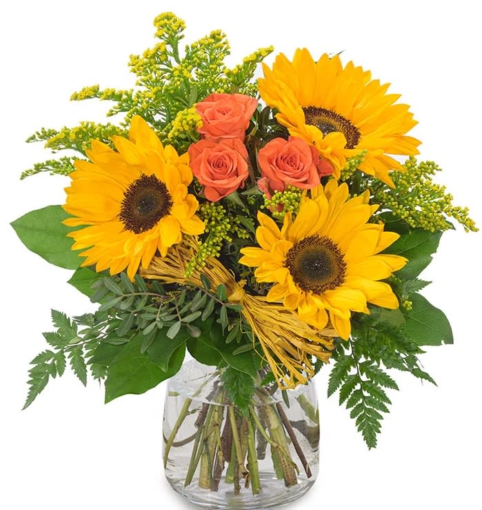 Sunflowers and coral roses in a clear glass vase