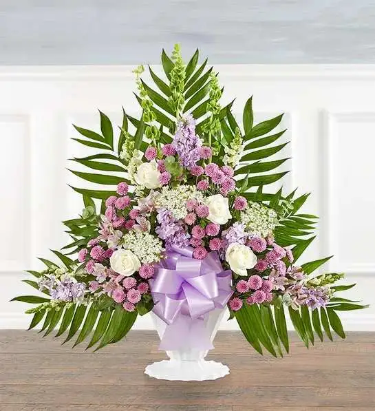 Tranquility Floor Basket  Lavender &amp; White - Offer comfort and tranquility with a truly special display. Our floor basket arrangement is a unique addition to the services, standing over three feet high with lush greenery that cascades out for an elegant presentation. This stylish design is gathered with a flourish of lavender &amp; white blooms, creating a beautiful tribute to celebrate their life.Floor basket arrangement with white roses, snapdragons and Queen Anne’s lace, lavender Peruvian lilies (alstroemeria), button poms and stock, green Bells of Ireland; accented with spiral eucalyptus