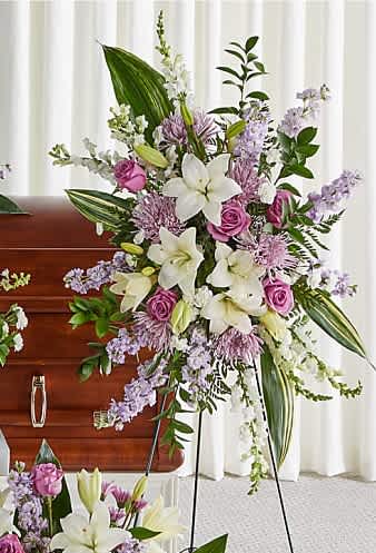 Tender Embrace  Standing Spray. - Featuring heartwarming lavenders and whites, the traditional arrangements .Standing Spray shares the warmth and comfort your loved ones need during this difficult time through each blushing bloom. 