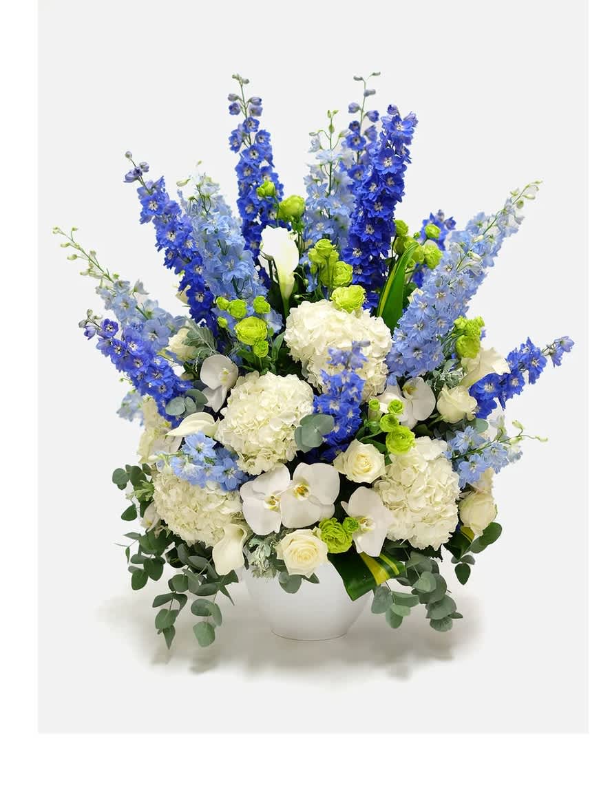 A majestic arrangement  - A majestic arrangement of white hydrangea, orchids, and roses, beautifully complemented with delicate blue delphinium. This premium flower box is carefully crafted using the freshest and highest-quality blooms, making it an ideal choice for any occasion, be it a special anniversary, a birthday celebration, or any other special moment.
