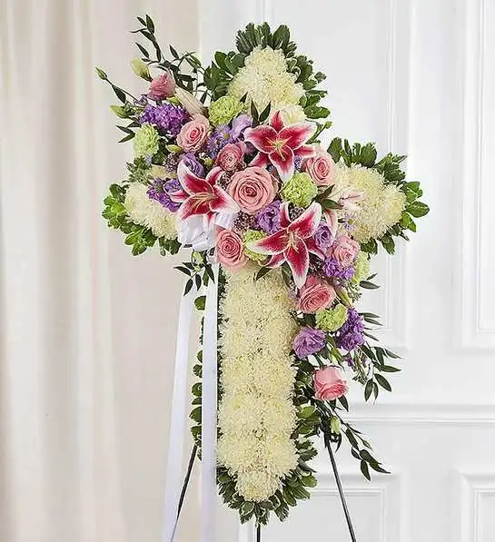 Peace &amp; Prayers  Standing Cross- Pastel - Express your faith, love and compassion in honor of a loved one with our beautiful standing cross arrangement. Our expert florists handcraft each of these impressive displays with a bed of white mums in the shape of a cross, and accent with a cascade of soft pastel blooms. It is a beautiful way to offer peace and comfort during a difficult time.