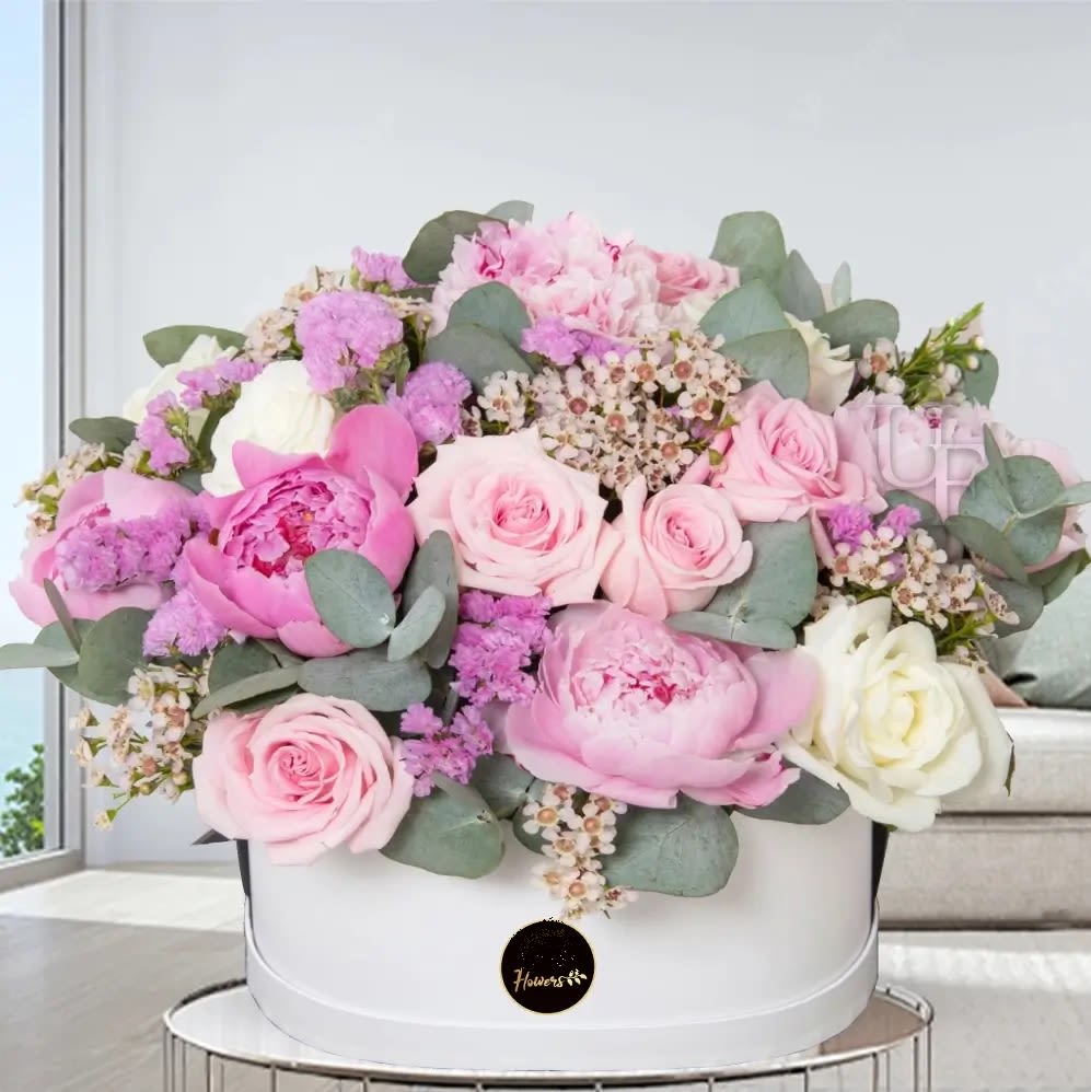 Pink and white roses with peonies in a white hat box