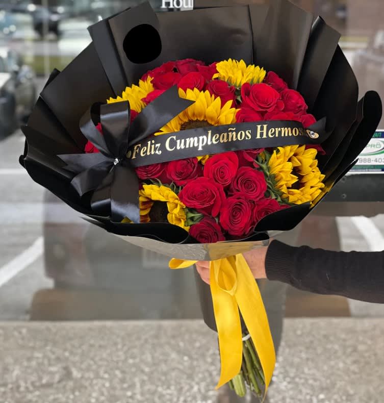 Bouquet of red roses and yellow sunflowers wrapped in black paper