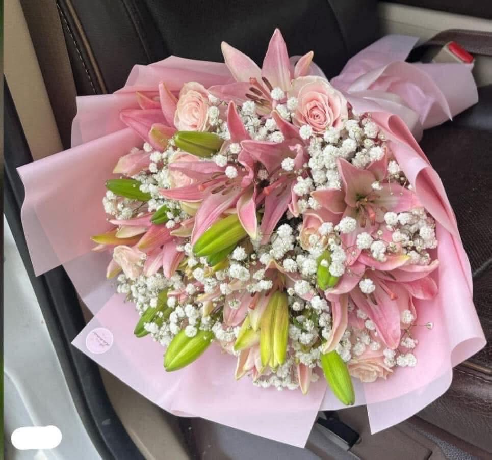 Pink lily and rose bouquet wrapped in pale pink paper
