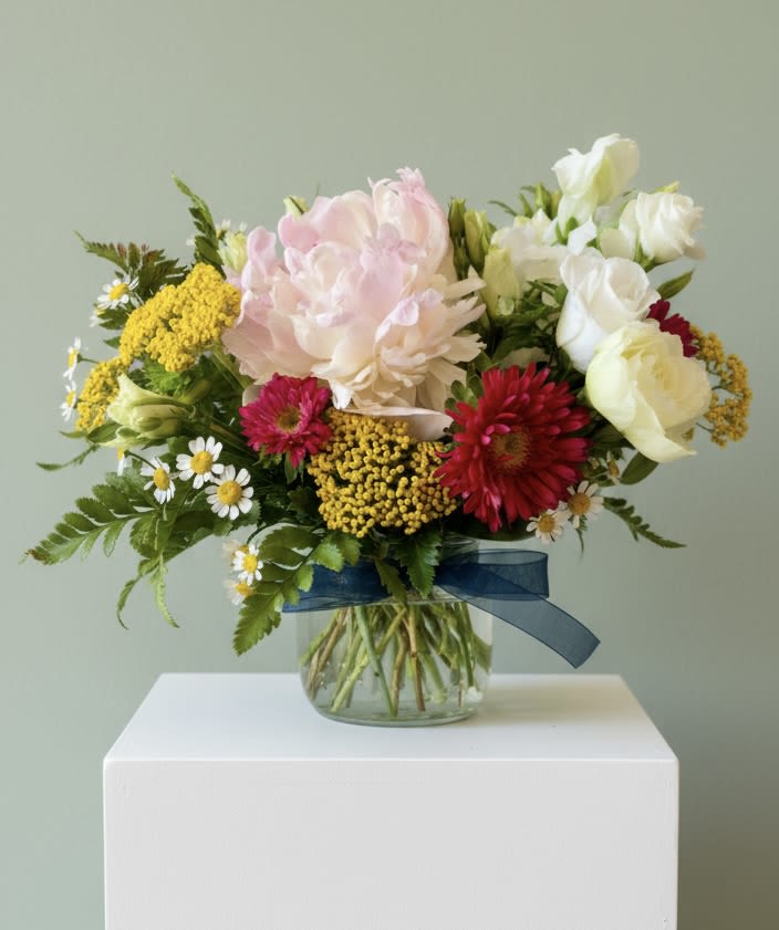 Endeavor Centerpiece (Designer’s Choice) - Endeavor (Designer’s Choice Centerpiece) is a collection of in season garden favorites and perfect for a graduation, a thank gift to a favorite professor or teacher or to say thank you to a friend or colleague. Glass vase included.   Every effort will be made to recreate your chosen design. Please note that from time to time due to product availability and quality we may need to make substitutions. We will make sure to keep the original design in mind when making substitutions. 