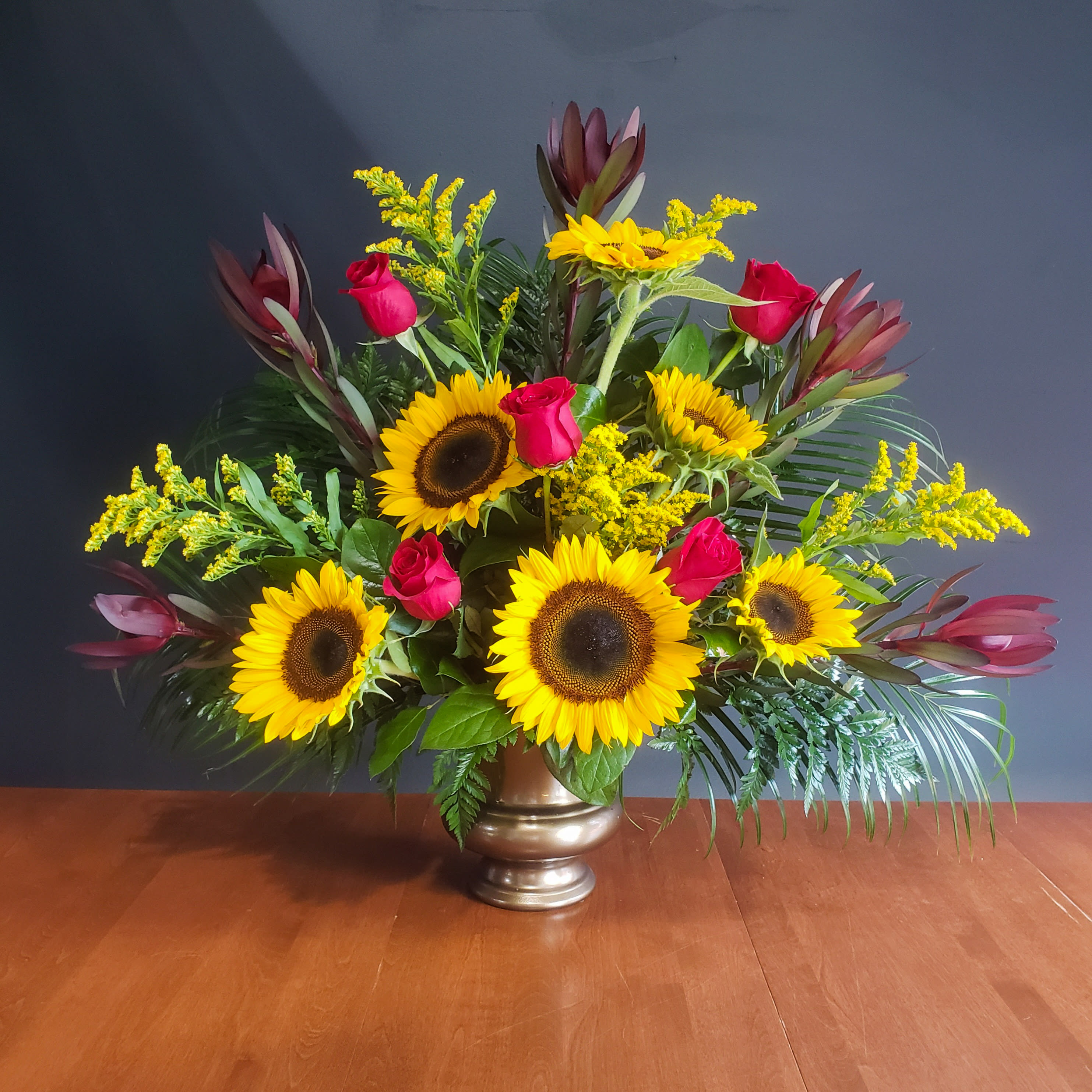 Red Rose and Sunflower Urn - A beautiful sympathy urn filled with red roses and sunflowers.